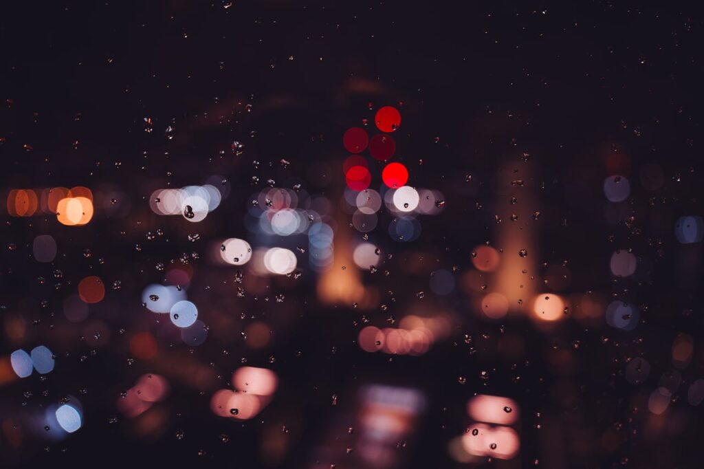 Bokeh city lights and raindrops on glass create a magical nighttime ambiance in London.