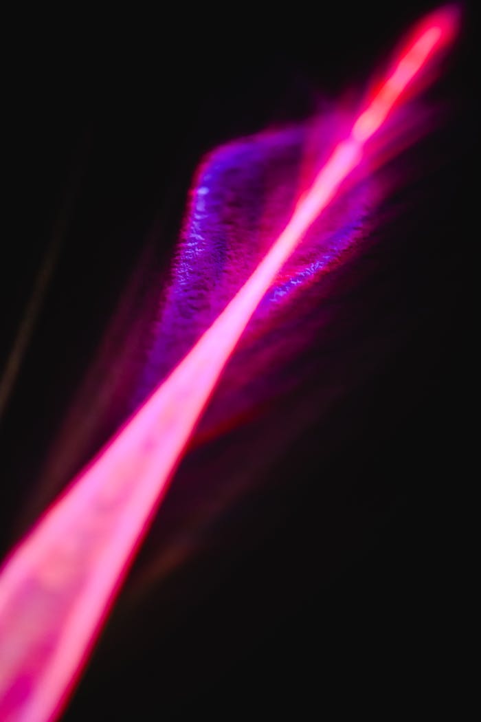 Abstract capture of a vibrant neon light streak on a dark background. Perfect for creative projects.